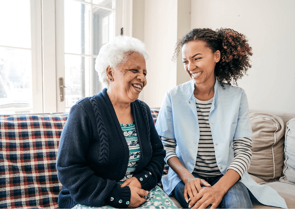 Two people smiling and talking on a couch