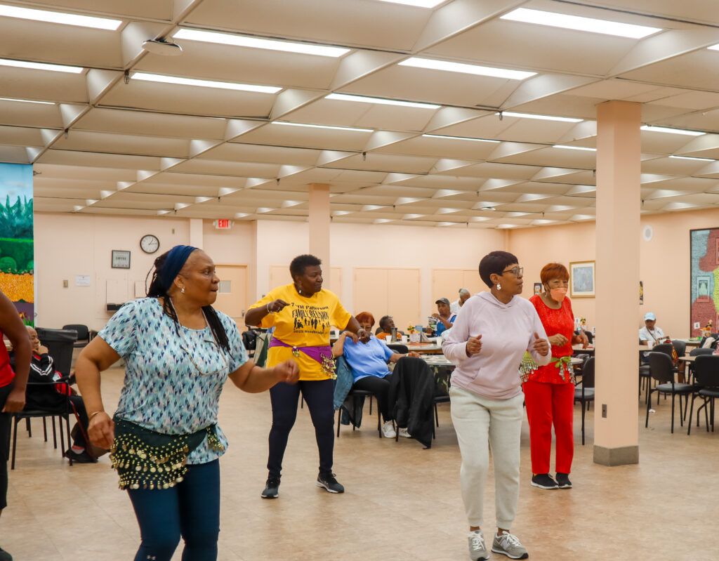 Group of older adults dancing in Southwest Senior Center