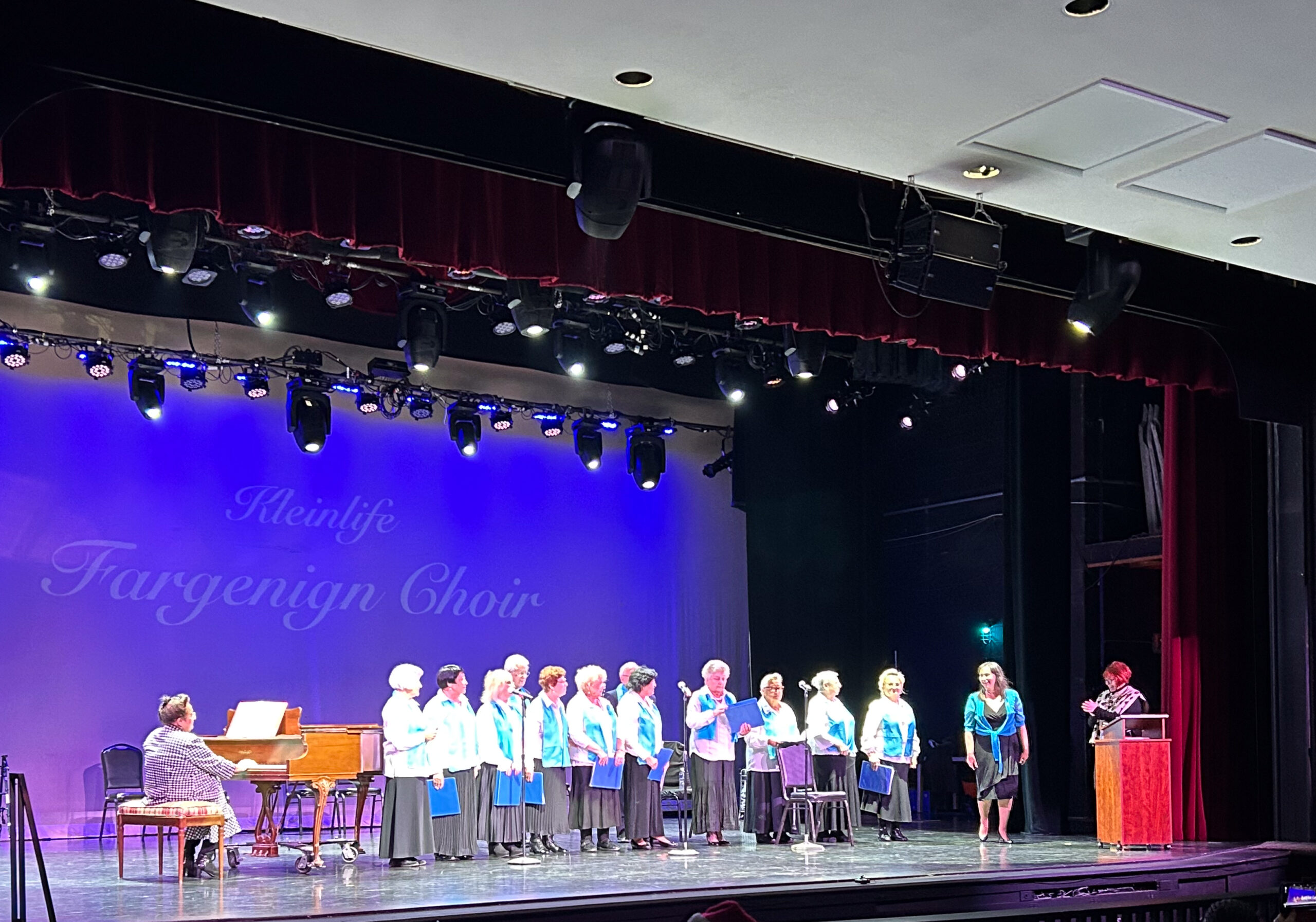 A group of older adults on stage in a choir.
